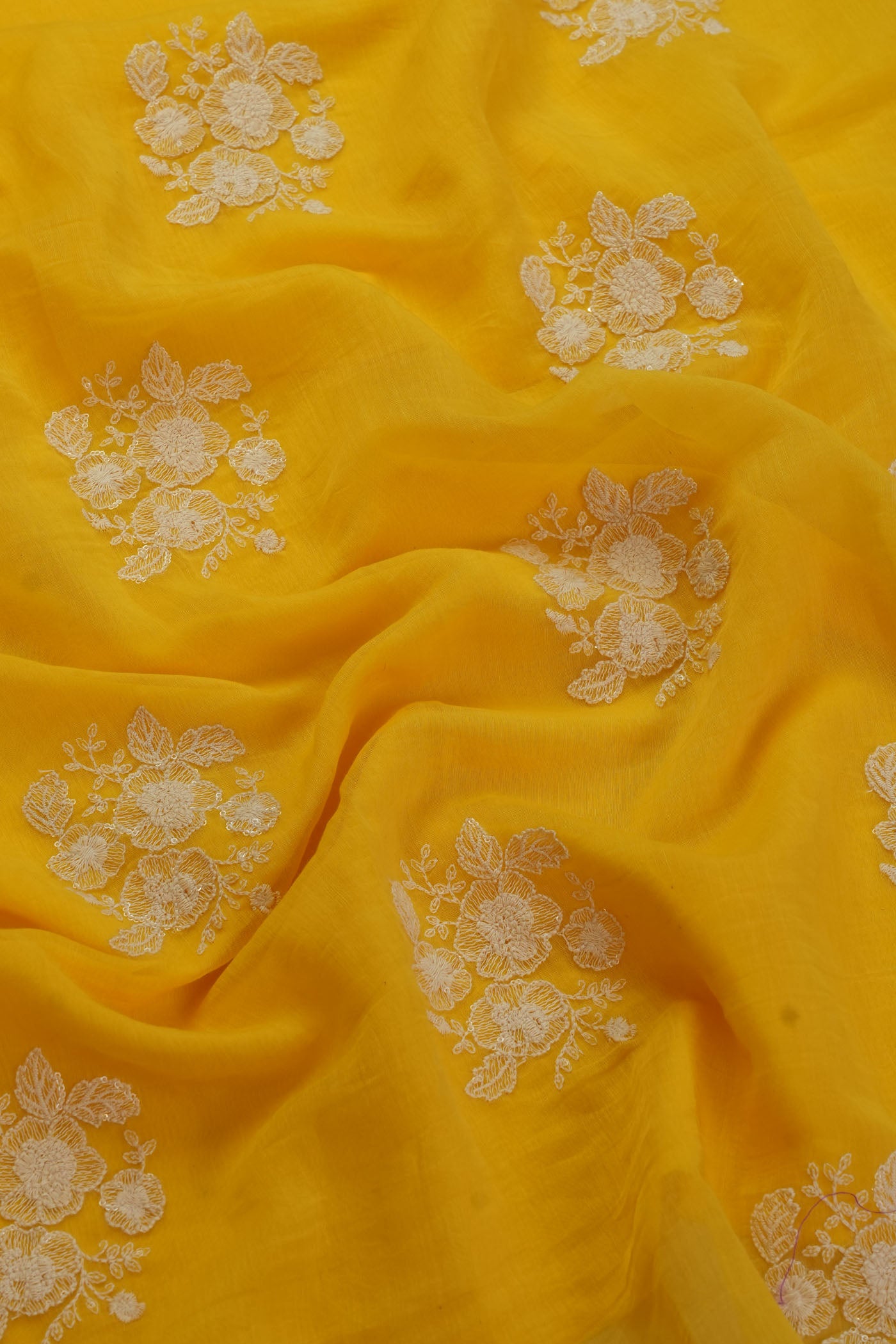 Vibrant Yellow Fabric with Intricate Floral Embroidery.