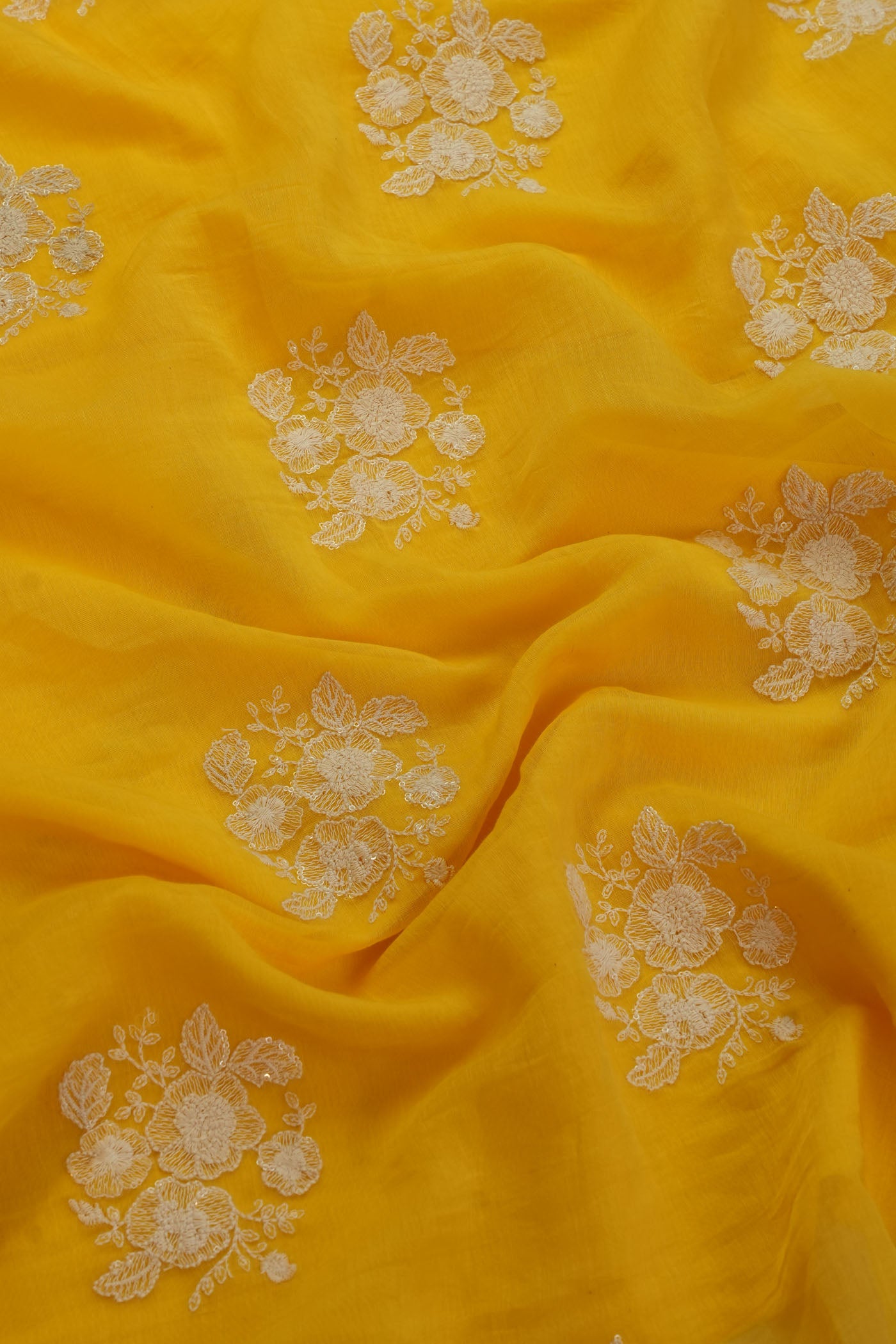 Vibrant Yellow   Fabric with Intricate Floral Embroidery.